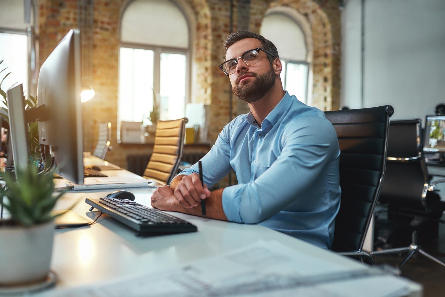 man at computer thinking looking inspired